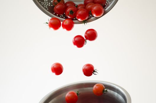 Cherry Tomatoes Tumbling Into Metal Colander