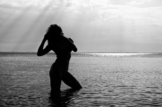 Black and white photo: Silhouette of woman in the sea