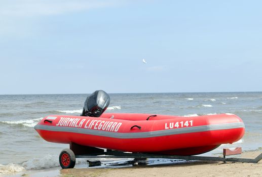 Rubber lifeguard boat trailer on sea shore 