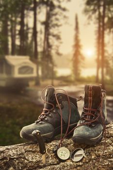 Hiking boots with compass at campsite