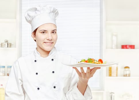 chef holding vegetarian meal in kitchen