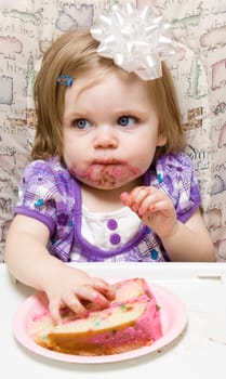Girl eating a slice of cake and making a mess