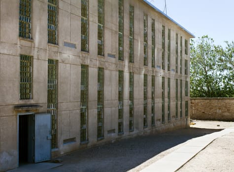 Prison building. can see windows with bars and an open door leading into the building
