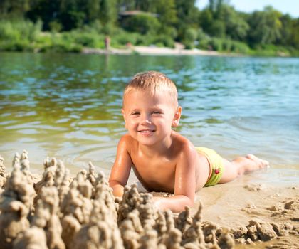 Happy kid playing at the beach in summer. River 