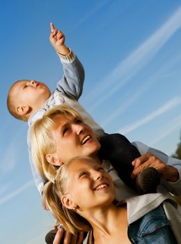 Healthy Family Outdoor. Happy Mother With Kids Over Blue Sky