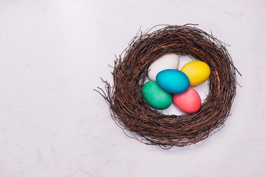 Easter eggs in nest on marble background