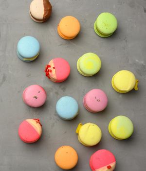 baked macarons with different flavors on a gray cement background, top view
