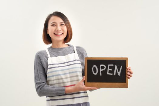 Portrait of young woman holding up an open signboard on white background