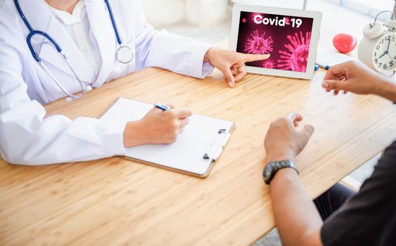 Medical Doctor Advising Coronavirus Disease and Health Care Consulting to Her Patient in Examination Room, Female Physician Doctor is Explaining Corona Virus Pandemic to Patient. Coronavirus Crisis
