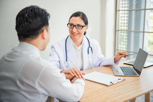 Medical Doctor is Encouraging and Health Care Consultation to Patient in Examination Room, Female Medicine Doctor Giving Encouragement and Consulting Health Problem to Male Patient. Encourage Concept