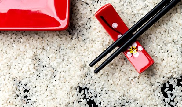 Japanese cuisine table setting with rice background and chopsticks