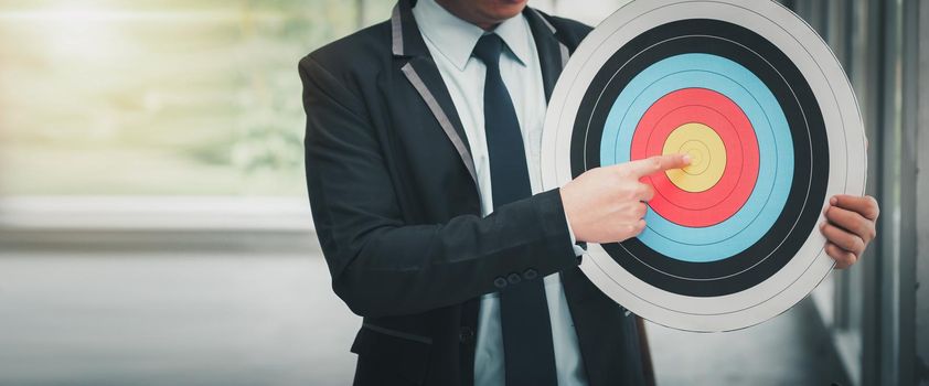 Business Man is Pointing Goal Target on Dartboard, Businessman Leadership Point to Strategic Marketing on Dartboard Bullseye Targeted to His Teamwork. Creative Idea for Project Achievement Strategy