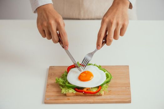 Delicious fried egg sandwich served on wooden board