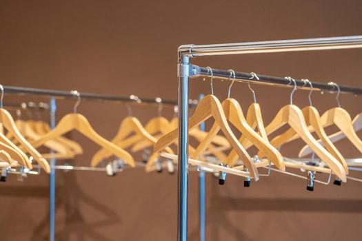 Wooden coat hangers on coat rack with no clothes in cloakroom