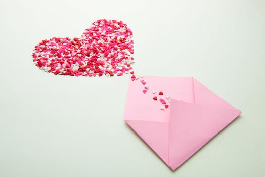 Sweets sugar candy hearts on envelope over green background