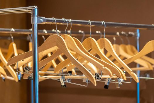 Wooden hangers on coat rack with no clothes in cloakroom or closet