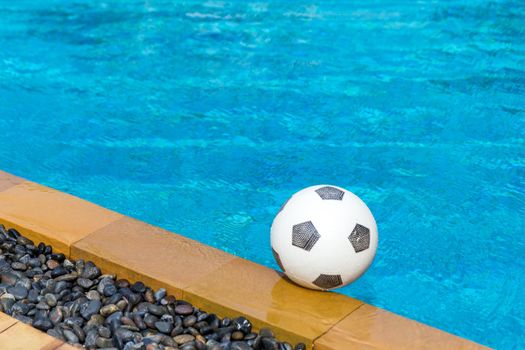 Soccer ball floating in the swimming pool