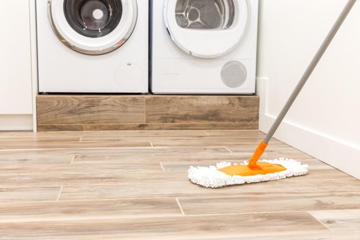 Cleaning floor in laundry room in modern house