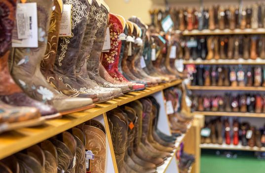 LOS ANGELES, CALIFORNIA, USA - MAY 20, 2015 - Close-up of new cowboy boots on shelf in Boot Barn store