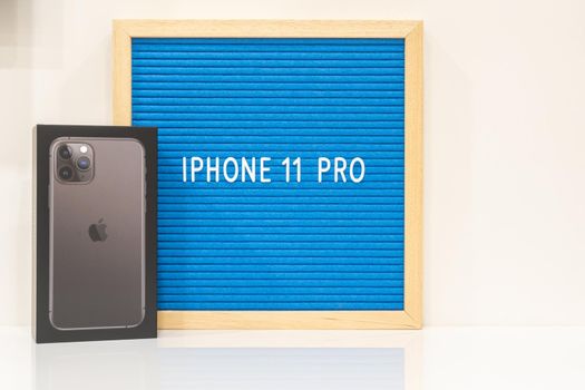 Moscow, Russia - September 24, 2019: Apple iPhone 11 pro in box standing near letter board
