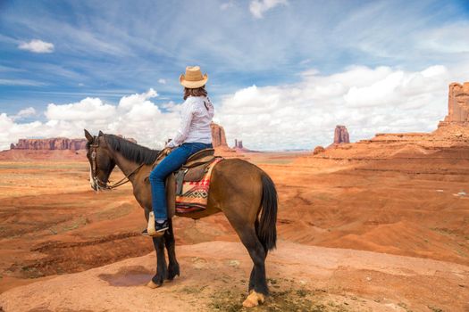 Cowgirl riding horse in Monument Valley Navajo Tribal Park in USA