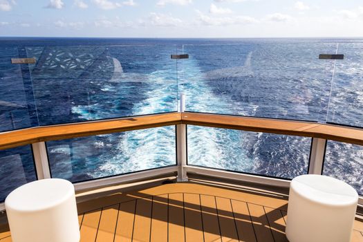 Deck of cruise ship with wake or trail on ocean surface, white trace