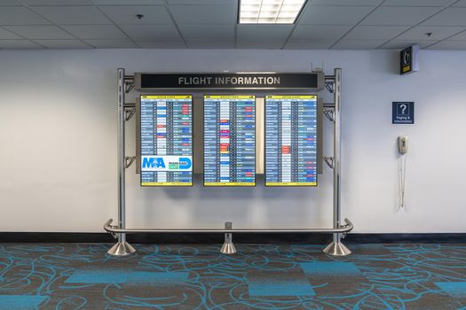 Miami, USA - September 11, 2019: Monitor at Miami International Airport lists scheduled departing flights with names of airlines