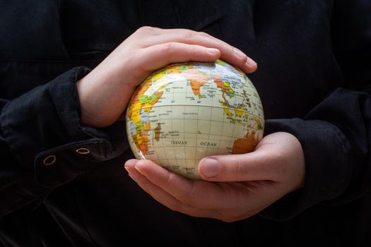 Person holding a globe model with hands