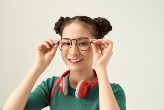 Young Asian woman with smiley face wearing glasses isolated on white background.