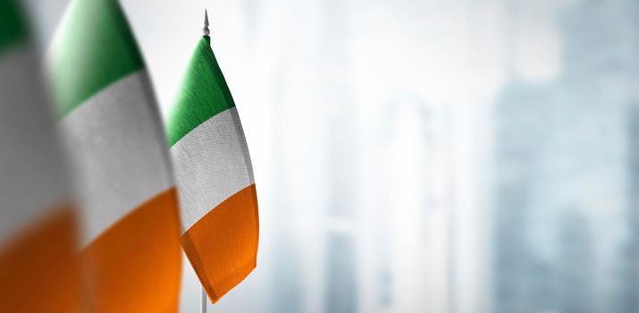 Small flags of Ireland on a blurry background of the city