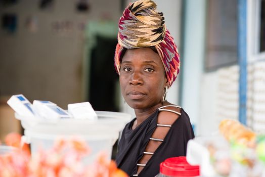 portrait of female saleswoman sitting behind her candy stand