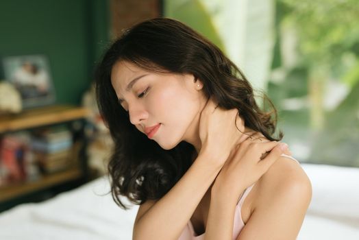 sick woman on bed concept of suffering from neck pain