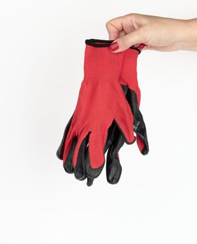 female hand holds textile red work gloves on a white background. Protective clothing for manual workers