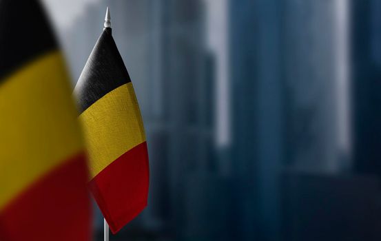 Small flags of Belgium on a blurry background of the city