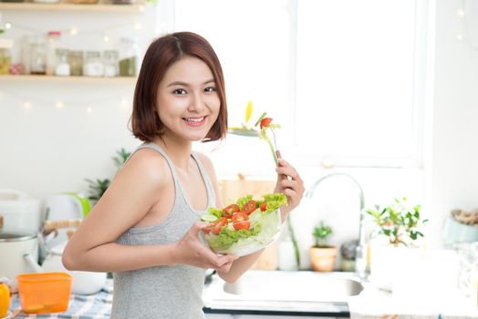 Dieting concept. Healthy Food. Beautiful Young Asian Woman eating fresh vegetable salad. Loosing Weight concept