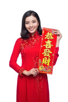 Portrait of a beautiful Asian woman on traditional festival costume Ao Dai showing  New Year scrolls Tet holiday. Lunar New Year.