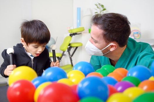 Physical therapist playing with children, with cerebral palsy