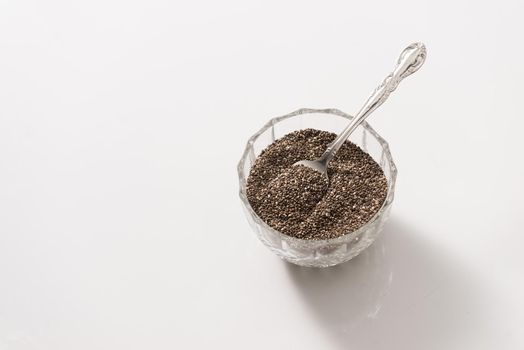 Chia seeds on white background. Chia seeds also known as superfood and used in a wide spectrum of diets.