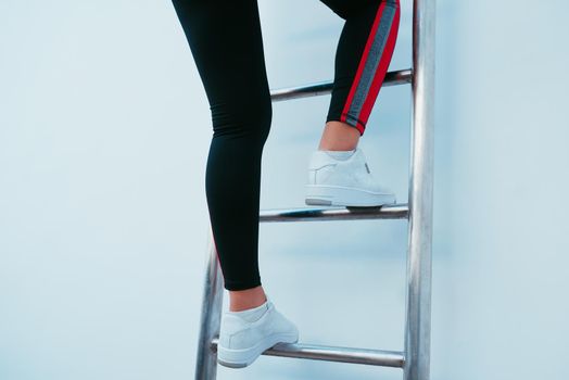 Sporty woman climbing the ladder. 