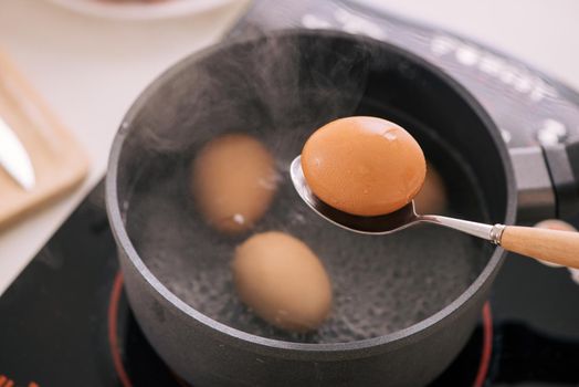Chef putting boiled eggs in cup / Cooking sweet brown Stewed pork gravy (Moo Pa-lo) concept