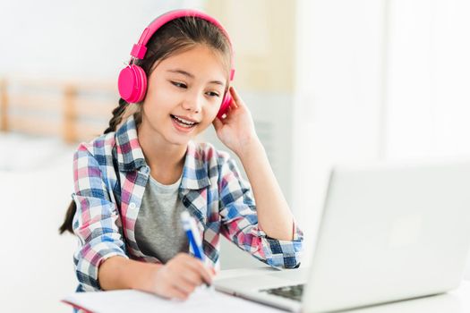 Happy student girl in headphones.Study online on laptop listening course.