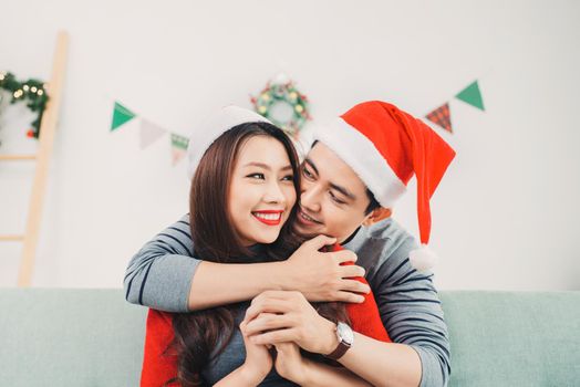 Christmas Asian Couple.Happy Smiling Family at home celebrating. New Year People