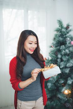 Christmas. Asian Pretty Woman  holding a gift celebrating New Year.