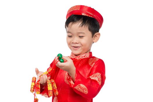 Portrait of a funny and exciting Vietnamese boy with firecrackers. Asian Kid Celebrating New Year