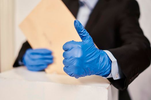A person in medical gloves voting