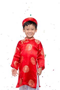 Happy Vietnamese boy in red Ao Dai celebrating New Year with confetti. Asian Kid Celebrating New Year