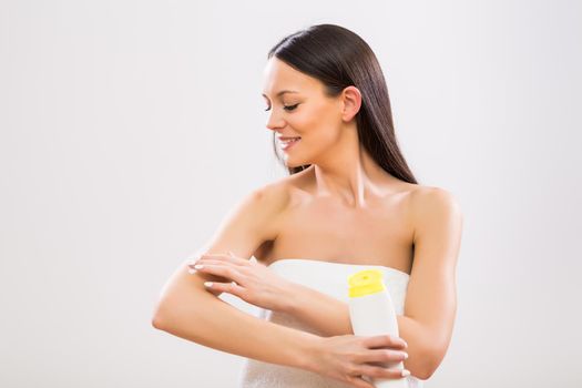 Woman applying moisturizer on her arm