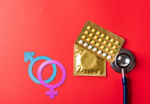 Male, female gender signs, condom in wrapper pack, birth control pill and doctor stethoscope