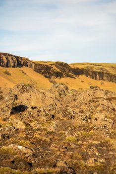 Icelandic topography with warm brown and orange tones and rocky texture with a blue sky