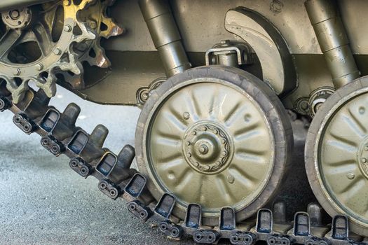 Tracked armor close-up. Black link tracks and large rubberized rollers. Chassis of an infantry fighting vehicle
